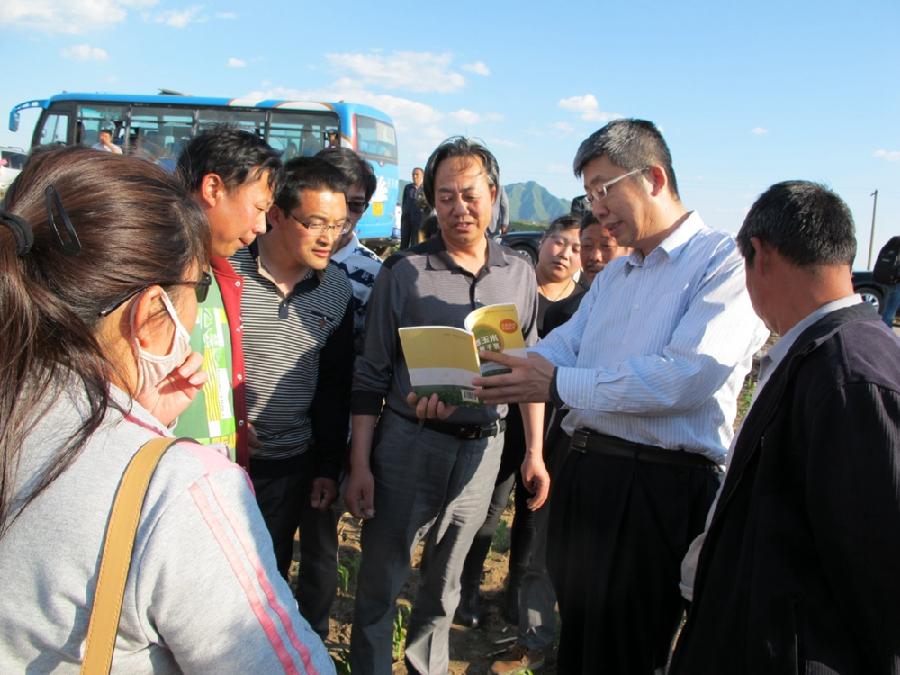 图3 李少昆（右2）介绍图册科普内容